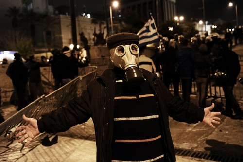 A protester wearing a gas mask poses for